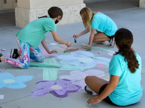 a group of girls painting on the ground
