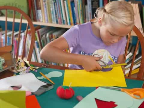 a girl coloring on a paper