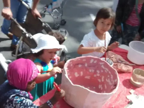 a group of children sitting at a table with food