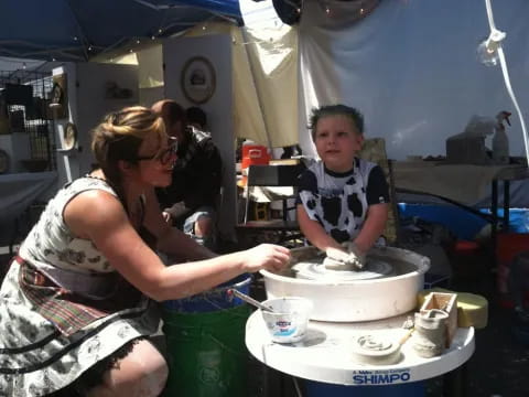 a woman and a boy cooking in a tent