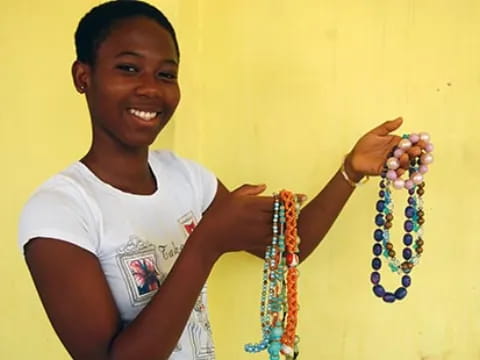 a young boy holding beads