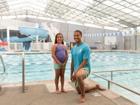 a man and woman posing for a picture next to a swimming pool