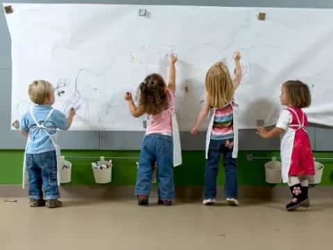 a group of children writing on a whiteboard