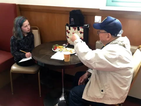 a man and a woman sitting at a table with food on it