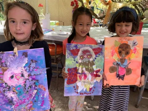 a group of children holding up artwork
