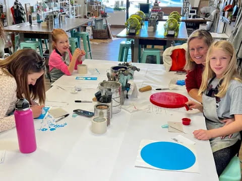 a group of children sitting at a table with toys