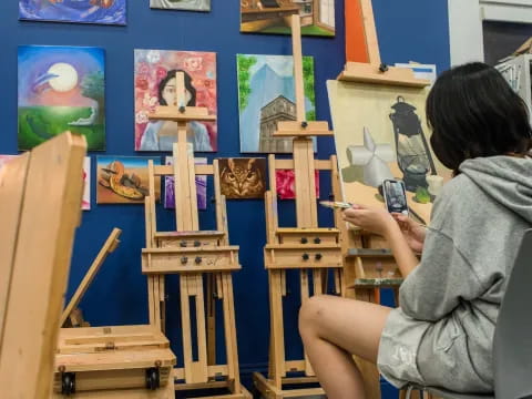 a woman painting on a easel