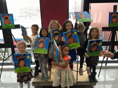 a group of children holding up toys