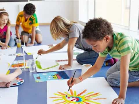 a group of children sitting on the floor playing a board game