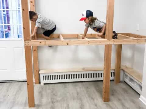 a couple of people climbing a wooden table