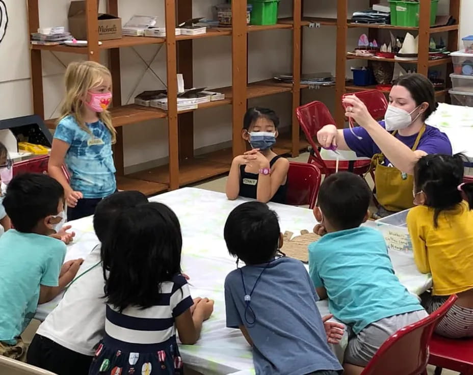 a group of children sitting in a circle in a classroom