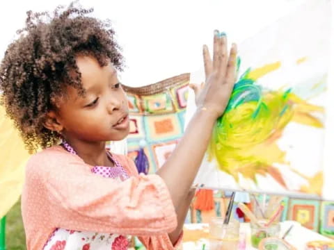 a little girl holding a yellow bird