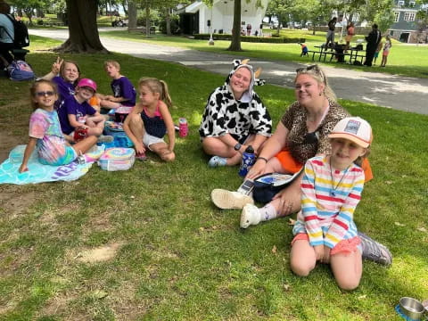 a group of people sitting on the grass