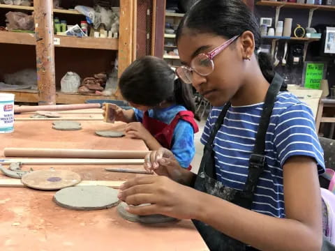 a person and a child working on a clay project