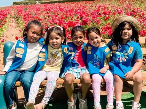 a group of people sitting on a bench posing for the camera