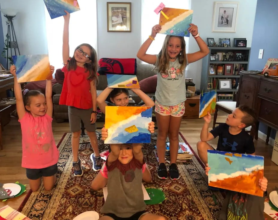 a group of children holding up a birthday cake