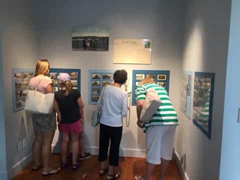 a group of people looking at pictures on a wall