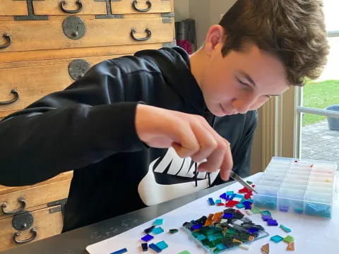 a man sitting at a table with a pile of small plastic pieces