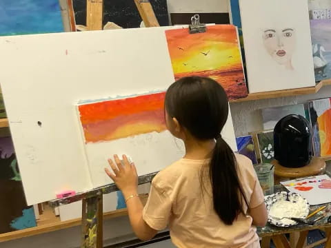 a girl painting on a white board