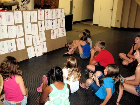 a group of children sitting on the floor in a classroom