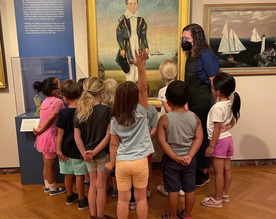 a group of children looking at a painting on a wall