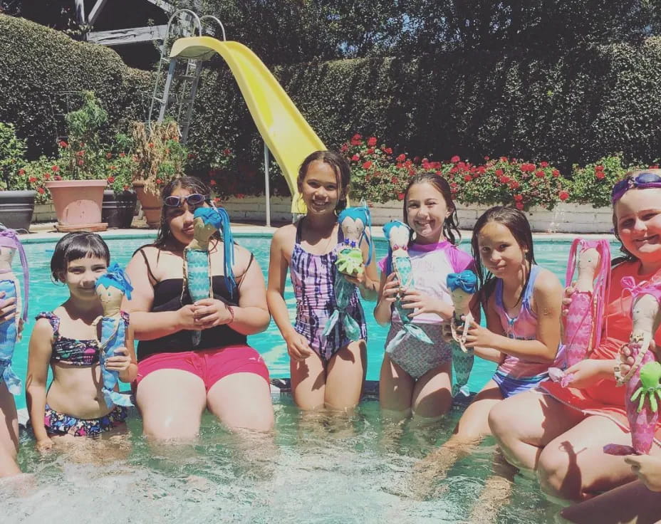 a group of girls in swimsuits in a pool