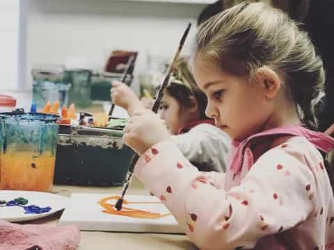 a young girl eating a spoon