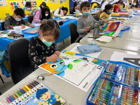 children sitting at desks with drawings