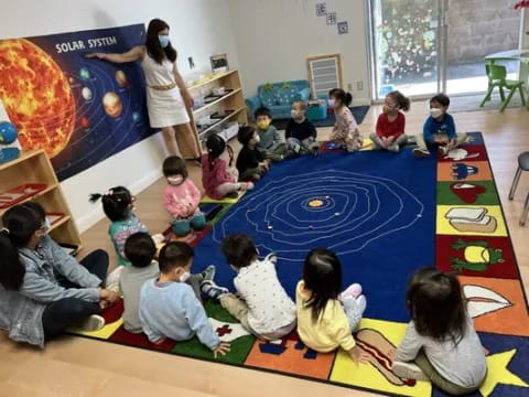 a group of children sitting on the floor in a classroom