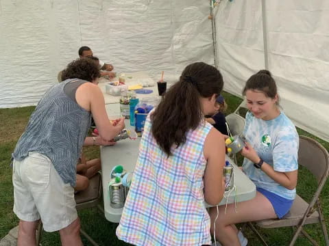 a group of people sitting around a table with food and drinks