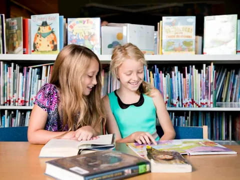 a couple of girls looking at books