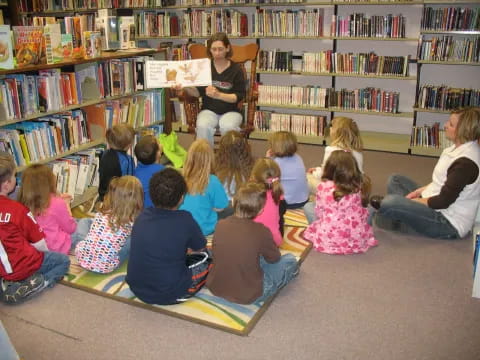 a person reading to a group of children in a library