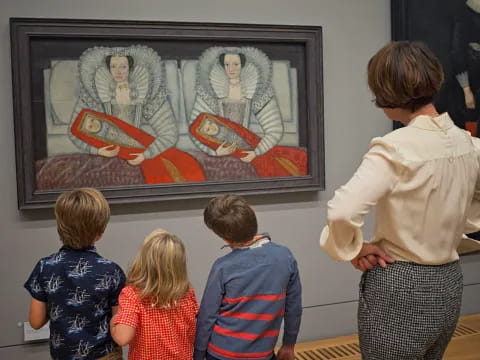 a group of children looking at a painting on a wall