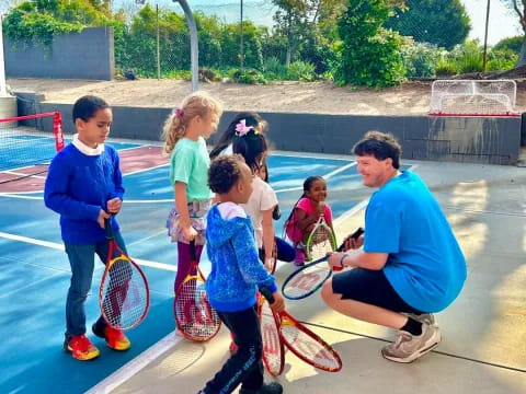 a group of kids holding tennis rackets