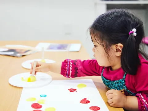 a young girl painting on a table