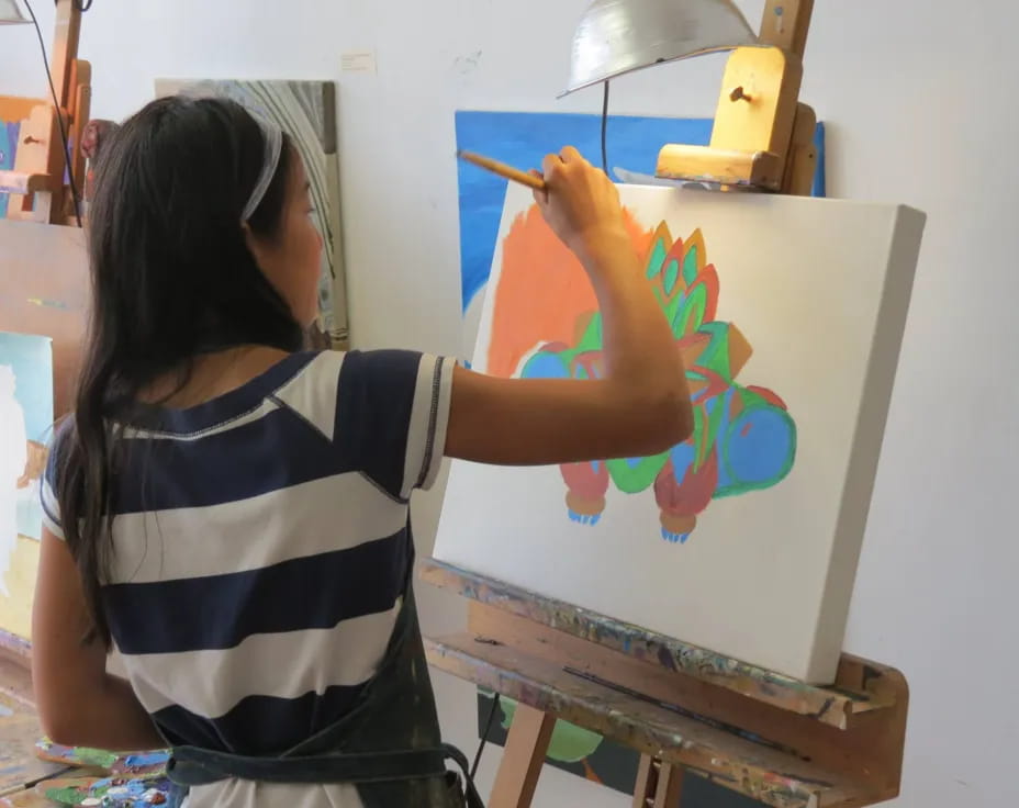 a woman painting on a white board