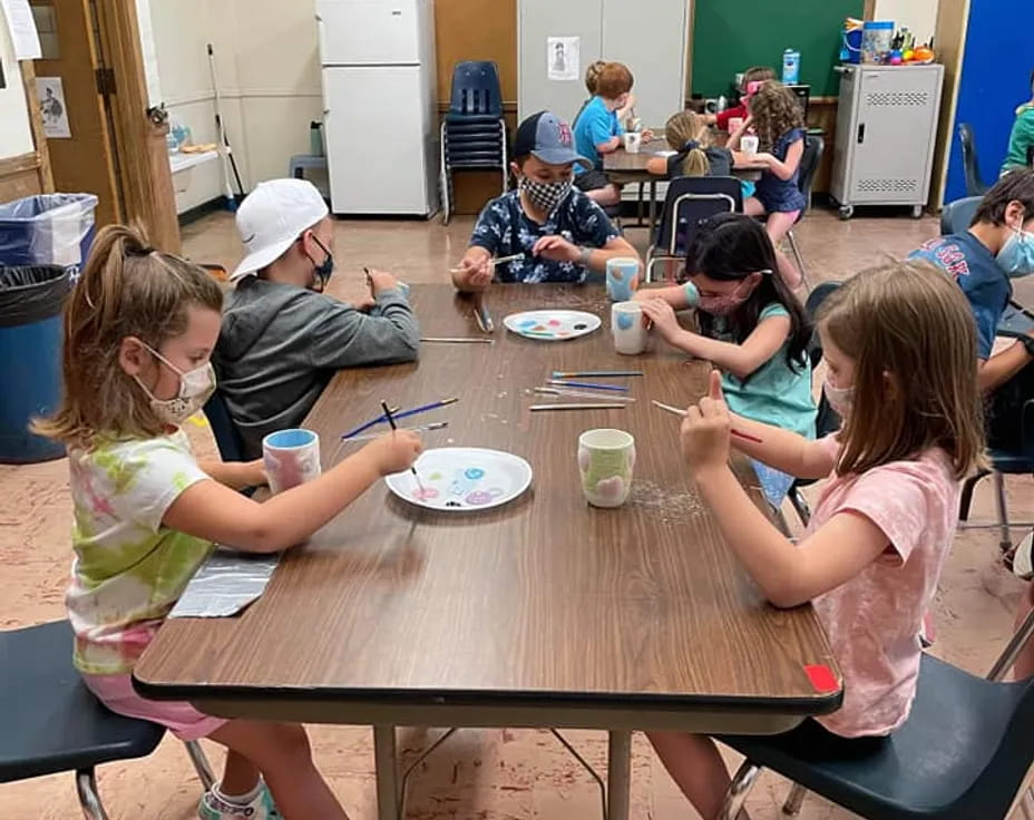 a group of children sitting around a table eating food