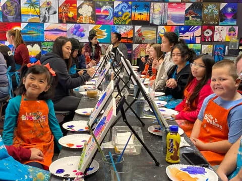 a group of people sitting at a table with pizzas