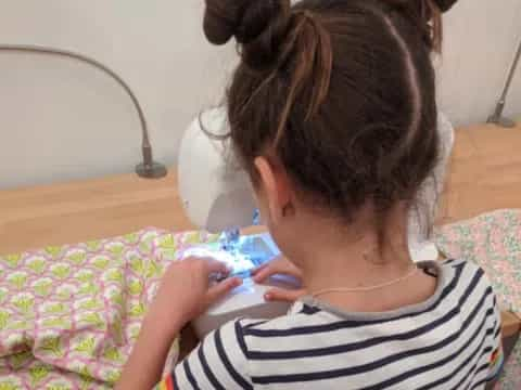 a young girl playing with a cell phone