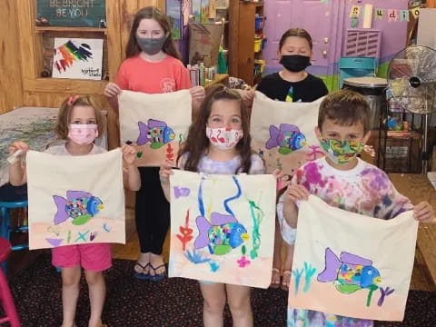 a group of children holding up colorful paper