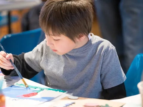 a young boy coloring on a paper