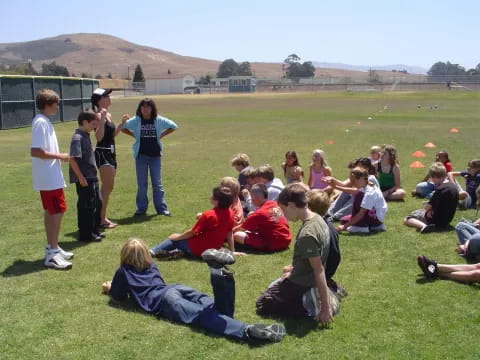 a group of people sitting on the grass