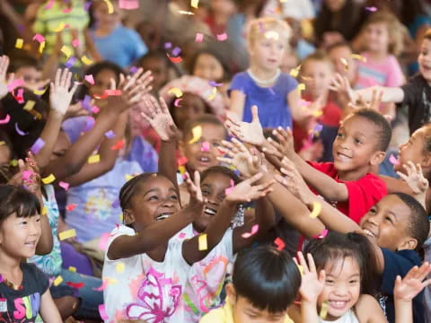 a group of children raising their hands