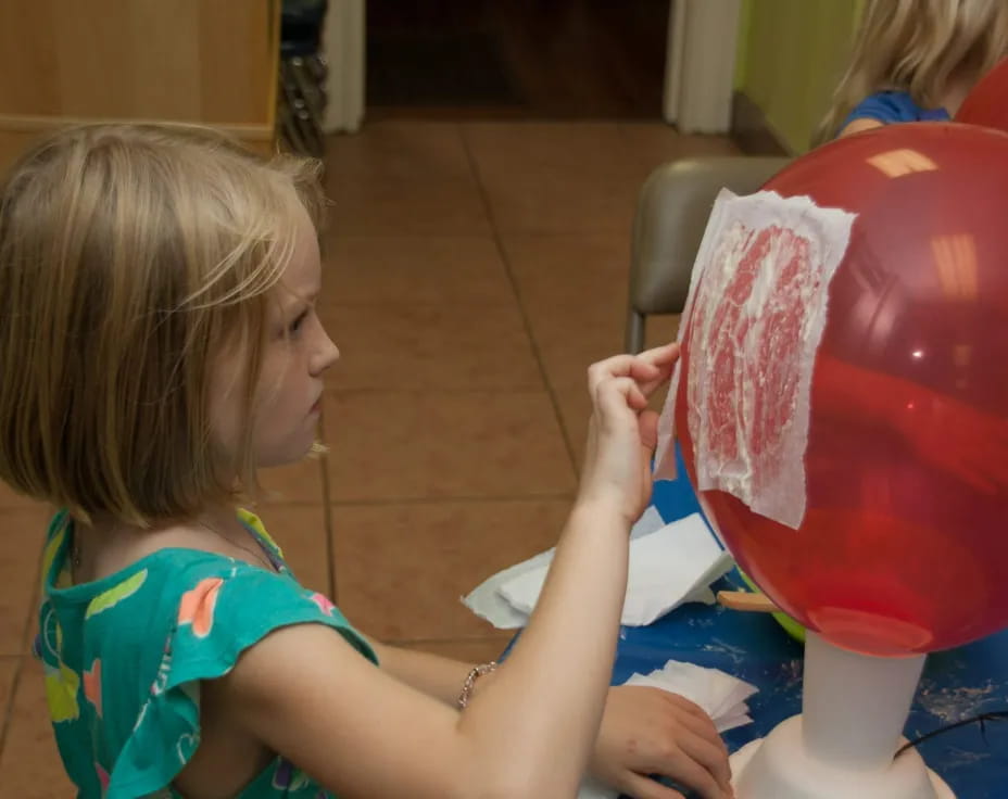 a child painting a pink vase