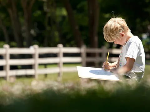 a young boy painting outside