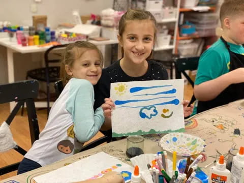 a few children holding a drawing