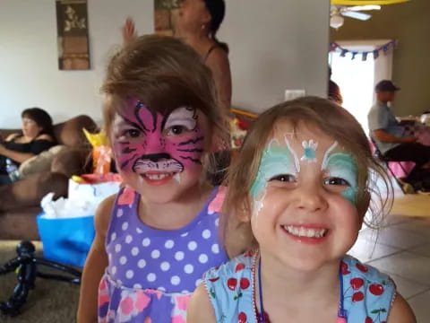 a couple of girls with paint on their faces