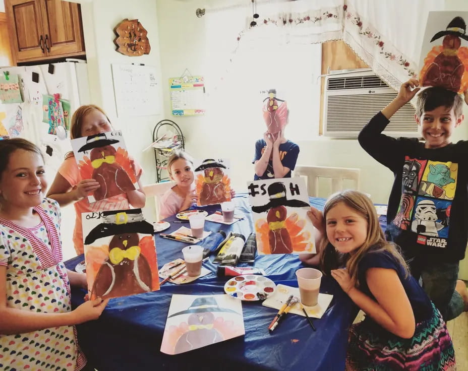 a group of children sitting at a table with toys