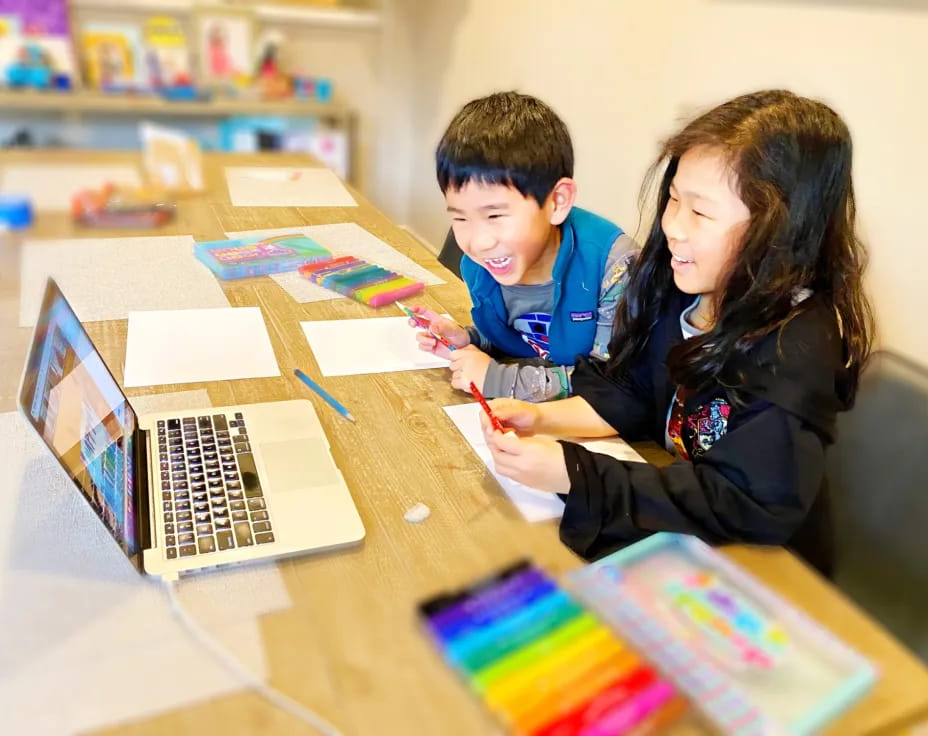 a person and a boy working on a laptop