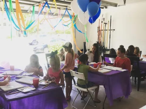 a group of people in a room with balloons